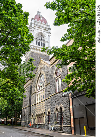 Gothic Revival First Congregational Church in downtown Portland, Oregon, showcasing its striking bell tower and intricate stone facade framed by leafy green trees Gothic Revival First Congregational Church in downtown Portland, Oregon, showcasing its striking bell tower and intricate stone facade framed by leafy green trees 128568156