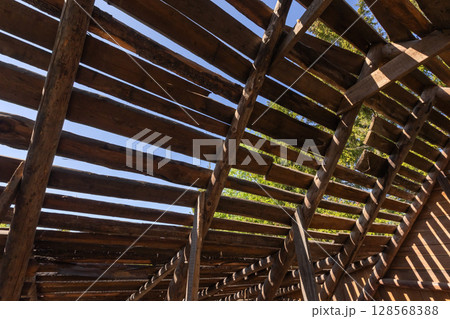 A close-up view of a rustic wooden structure showing the exposed beams 128568388