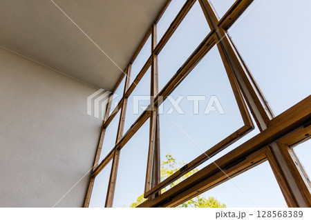 Wooden window frames with clear glass panes on a sunny day Wooden window frames with clear glass panes on a sunny day 128568389