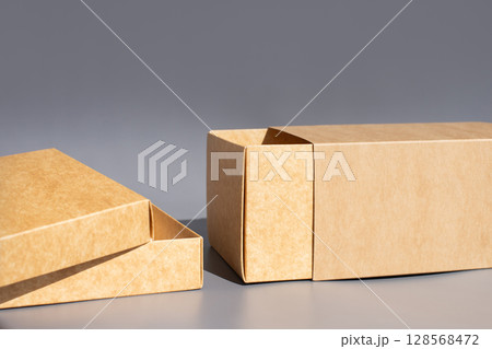 Cardboard packaging box set with open lid on gray background. International Box Day Cardboard packaging box set with open lid on gray background. International Box Day 128568472