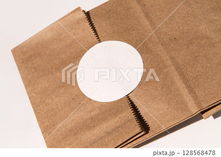 Open brown paper bag with circular cutout on white surface Open brown paper bag with circular cutout on white surface 128568478