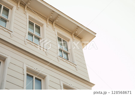 Architectural features and windows of a vintage building Architectural features and windows of a vintage building 128568671