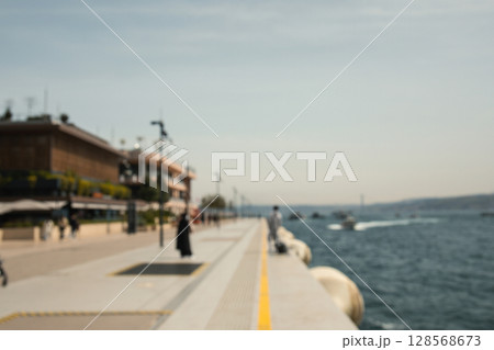 People enjoy leisure time by the water on a warm afternoon 128568673