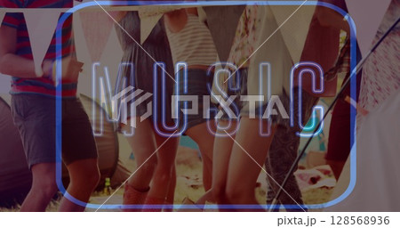 Image of neon music text in blue over friends dancing at beach party 128568936