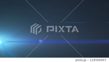 Image of blue spotlight with lens flare on dark background 128568947