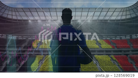 Image of graphs and data processing over rugby player holding ball at sports stadium 128569019