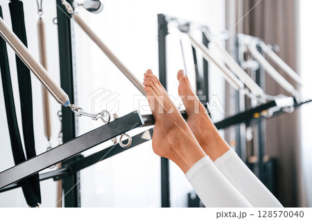 Close up view. Young woman in fitness center is doing exercises 128570040