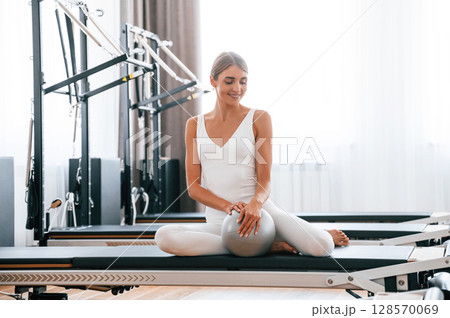 Using fitness ball. Young woman is doing exercises Using fitness ball. Young woman is doing exercises 128570069