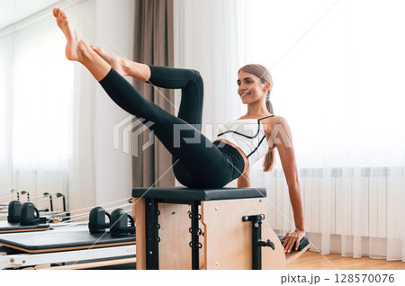 On the leg. Young woman in fitness center is doing exercises On the leg. Young woman in fitness center is doing exercises 128570076