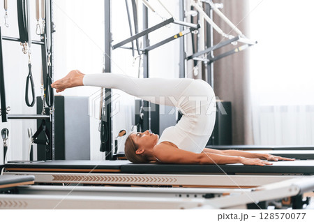 Legs are up. Young woman in fitness center is doing exercises 128570077