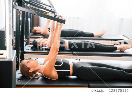 Women in fitness center are doing exercises Women in fitness center are doing exercises 128570133