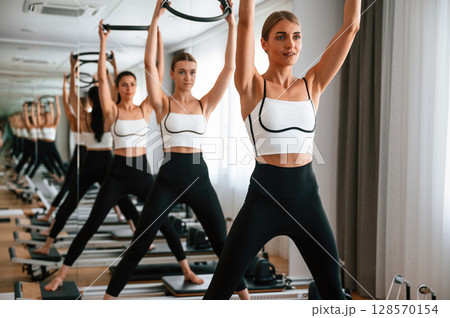 Exercises by using the circle device in hands. Women in fitness center 128570154