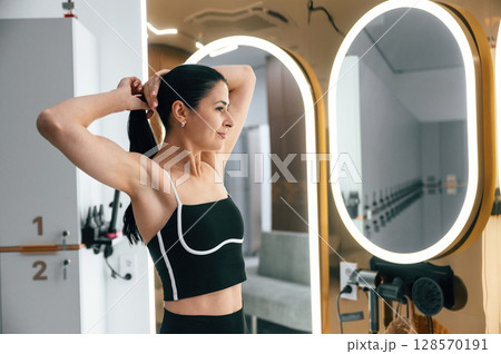 Woman is taking care of her hair in the changing room 128570191
