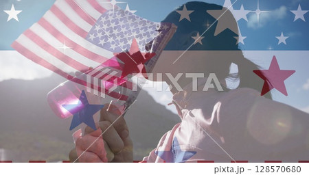 Image of american flag over biracial woman drinking water in mountains Image of american flag over biracial woman drinking water in mountains 128570680