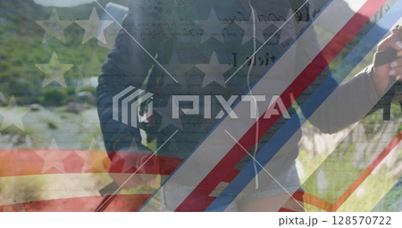 Image of american flag over biracial woman hiking in mountains Image of american flag over biracial woman hiking in mountains 128570722