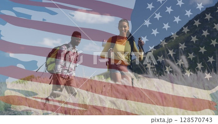 Image of american flag over smiling diverse couple hiking in mountains 128570743
