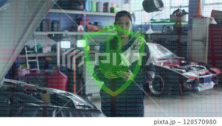 Image of padlock and shield icon over biracial female car mechanic using tablet at garage Image of padlock and shield icon over biracial female car mechanic using tablet at garage 128570980
