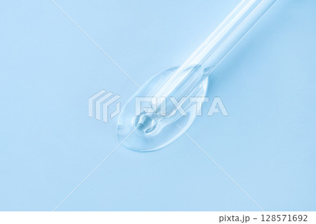Drop of cosmetics and a pipette on a white background. Drop of cosmetics and a pipette on a white background. 128571692