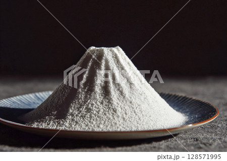 皿の上に富士山のように盛られた白い粉末の演出 128571995