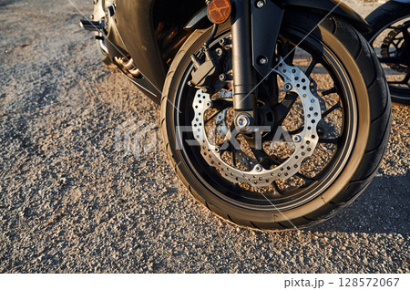 Close up view of modern motorcycle that is parked outdoors 128572067