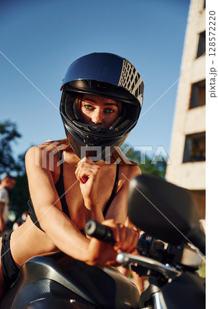 In protective helmet. Hot woman in underwear is with motorcycle outdoors 128572220