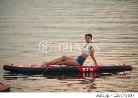 Young woman is on sup boards in the lake Young woman is on sup boards in the lake 128572637
