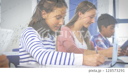 Image of mathematical equations with school children using laptop in classroom 128573291