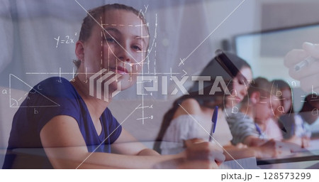 Image of mathematical equations over school children writing in classroom Image of mathematical equations over school children writing in classroom 128573299