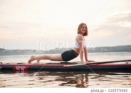 Exercises for the spine. Young woman is on sup boards in the lake 128573492