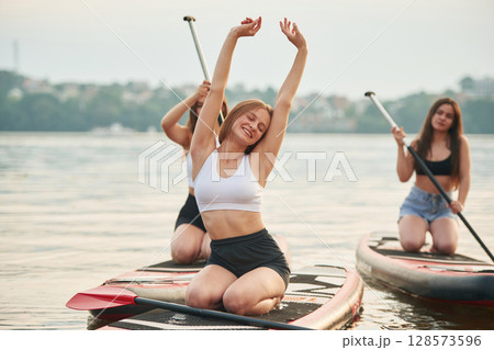 In the lake. Young women are on sup boards 128573596