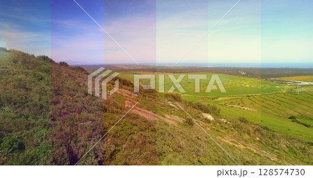 Composite image of transparent striped overlay against aerial view of grassland Composite image of transparent striped overlay against aerial view of grassland 128574730