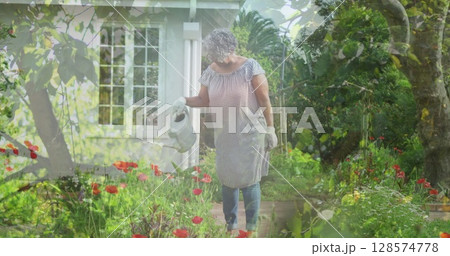 Image of trees over senior caucasian woman watering plants in garden Image of trees over senior caucasian woman watering plants in garden 128574778