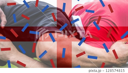 Image of flag of england and confetti over caucasian male rugby players at stadium 128574815