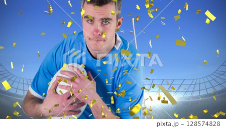 Image of confetti over caucasian male rugby player with ball at stadium Image of confetti over caucasian male rugby player with ball at stadium 128574828