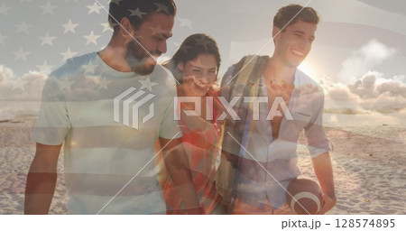 Image of flag of united states of america over happy diverse friends on beach 128574895