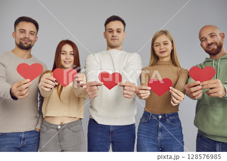 Group of young people holding paper red love heart, showing loving relationships, understanding Group of young people holding paper red love heart, showing loving relationships, understanding 128576985