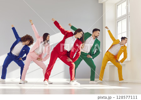 Group of young people dancers wearing bright stylish trendy suits dancing together in modern studio 128577111