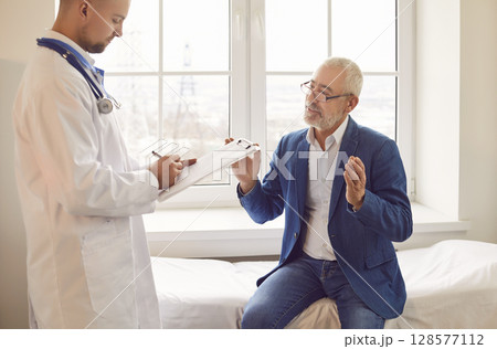 Elderly Male Patient Consulting with Doctor or Nurse in Hospital Office Elderly Male Patient Consulting with Doctor or Nurse in Hospital Office 128577112