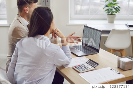 Business people looking at laptop screen together, view from behind. 128577154