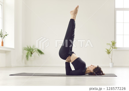 Young yogi attractive slim woman practicing yoga, standing in Shoulder stand exercise Young yogi attractive slim woman practicing yoga, standing in Shoulder stand exercise 128577226