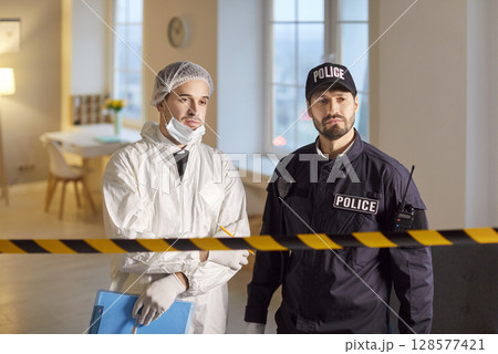 Portrait Of Policeman And Criminologist At Crime Scene During Investigation 128577421