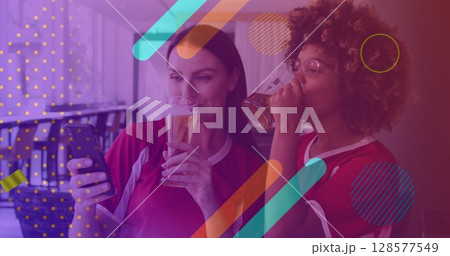 Image of confetti over happy diverse female friends using smartphone Image of confetti over happy diverse female friends using smartphone 128577549