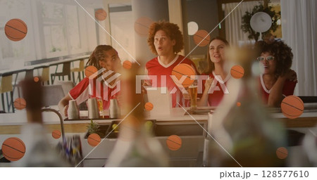 Image of basketball icons over smiling diverse friends watching tv and drinking beer 128577610
