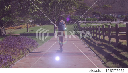Image of light spots over biracial woman riding scooter Image of light spots over biracial woman riding scooter 128577621