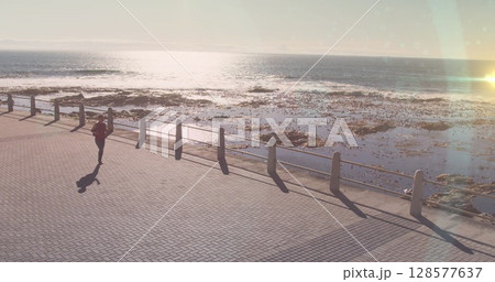 Light spot against aerial view of african american fit woman running on the promenade Light spot against aerial view of african american fit woman running on the promenade 128577637
