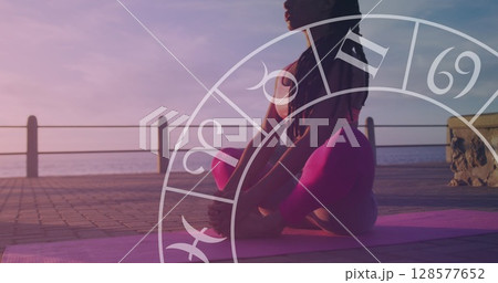 Image of horoscope over biracial woman meditating on promenade 128577652
