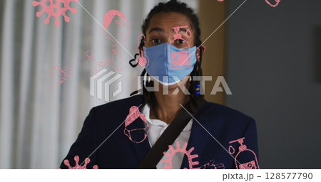 Image of pandemic icons over biracial man with face mask 128577790