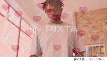 Image of hearts and mathematical equations over african american man painting 128577822