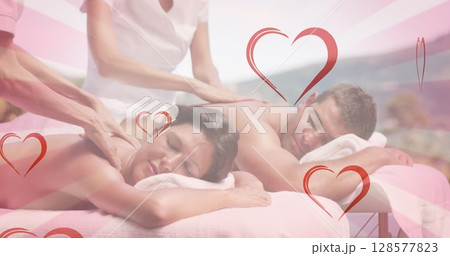 Image of hearts falling over caucasian couple in spa during massage 128577823