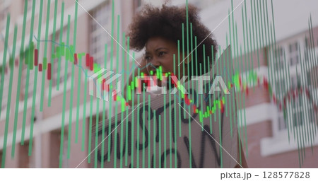 Image of financial data processing over african american woman protesting 128577828